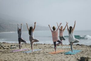 Yoga students practicing near the ocean beach in Sri Lanka during sunrise